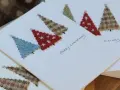 Tarjetas de Navidad para dibujar con árboles de tela cosidos. Un diseño encantador para crear tus propias felicitaciones.