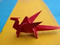 Un dragón rojo de papiroflexia, listo para seguir las instrucciones.