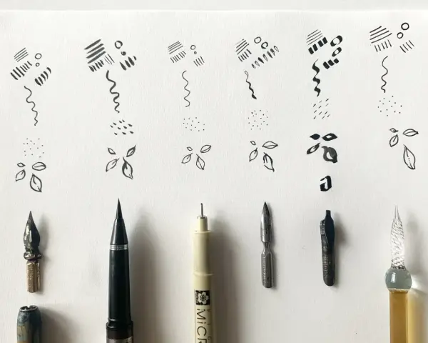 Ejemplos de trazos y formas básicas en dibujos con tinta china, junto a varias plumas y puntas de caligrafía.