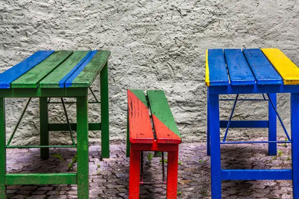 Muebles coloridos, como mesas y bancos, hechos con **objetos reciclados fáciles de hacer**.