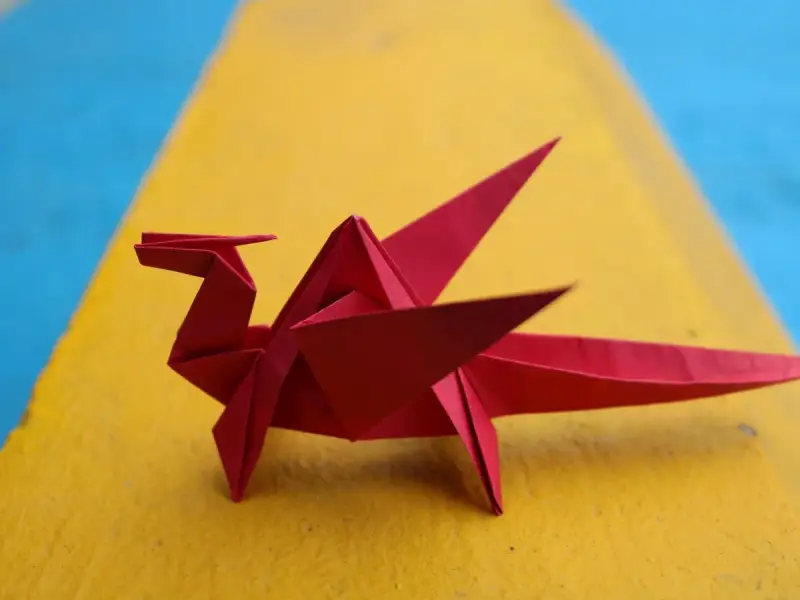 Un dragón rojo de papiroflexia, listo para seguir las instrucciones.